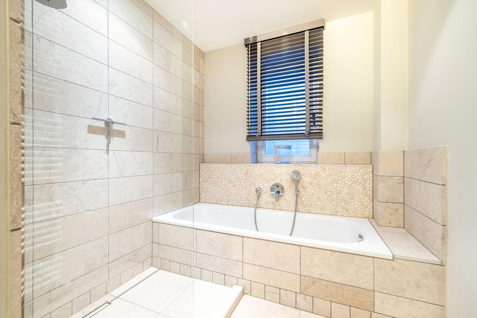 Bad mit Dusche und Badewanne, Fenster mit Jalousie, Fliesenwand