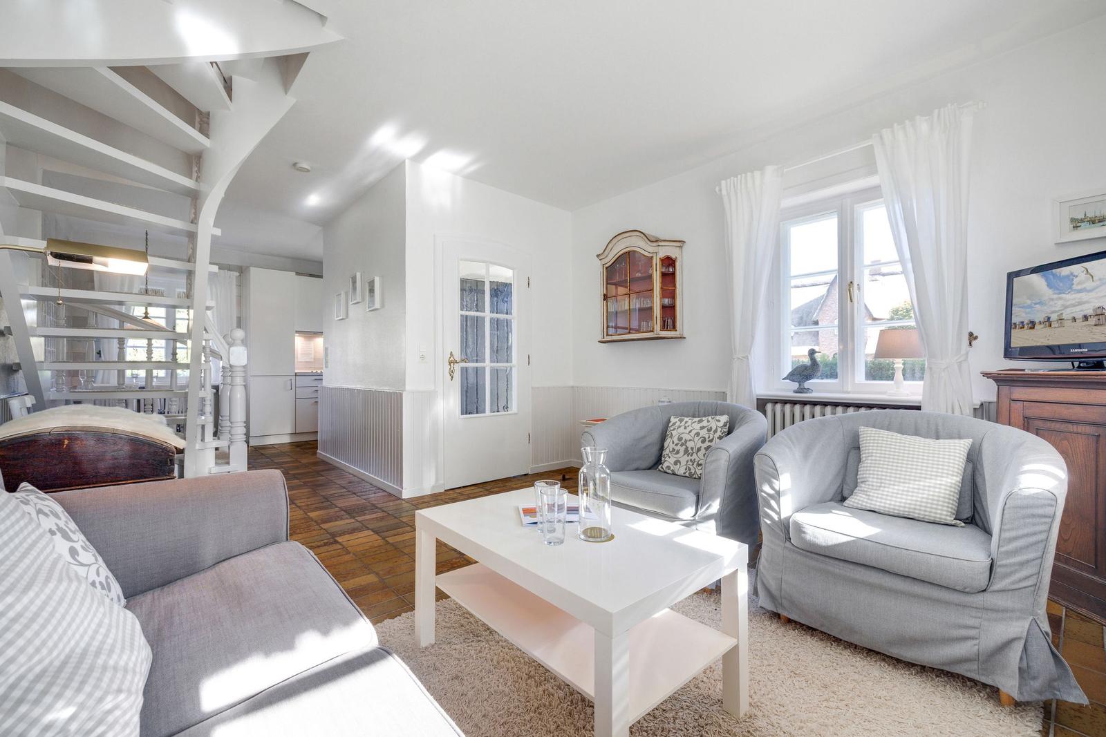Living room with two armchairs, sofa, coffee table, and window.