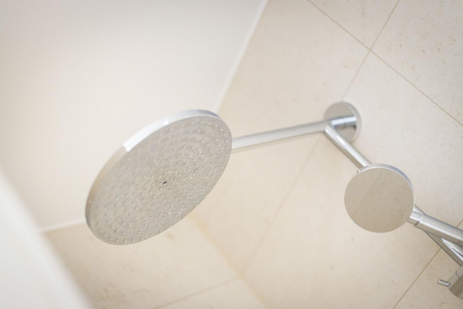 Duschkopf mit Duschbrause und Armatur an Wand