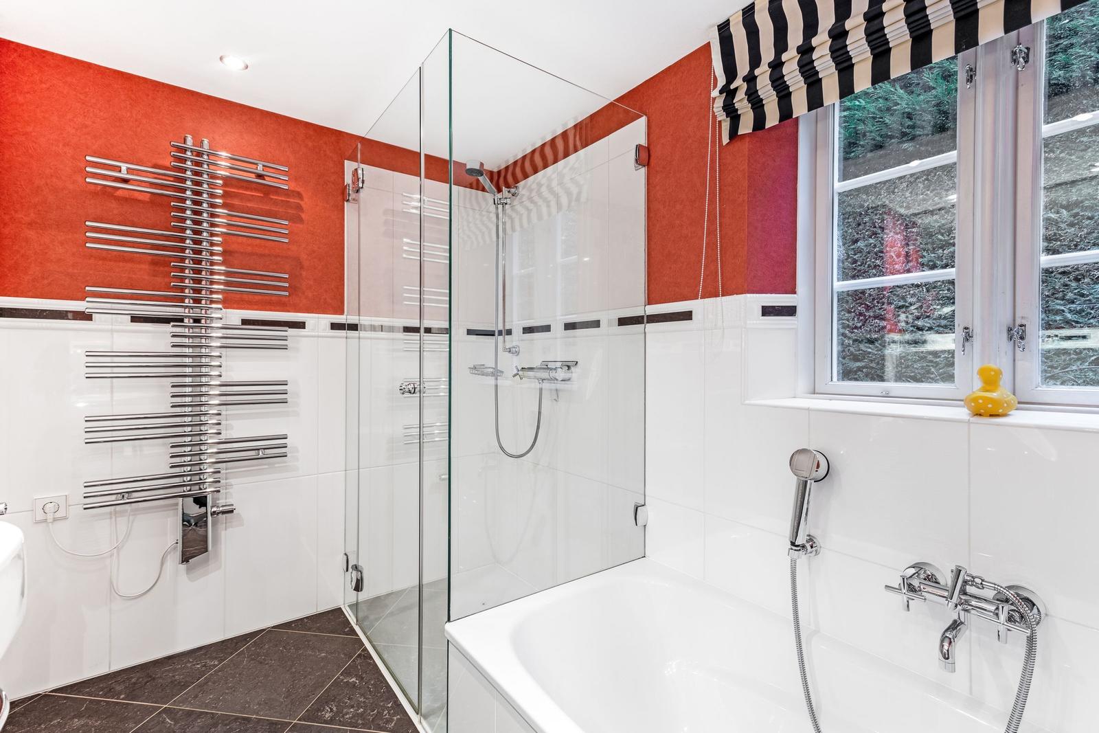 Badezimmer mit Dusche, Badewanne und Fenster