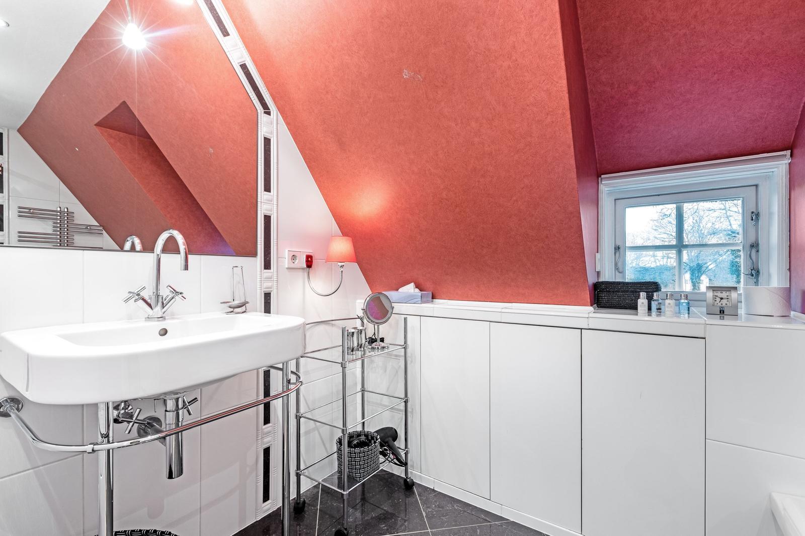 Badezimmer mit rotem Dach, Waschbecken und Fenster