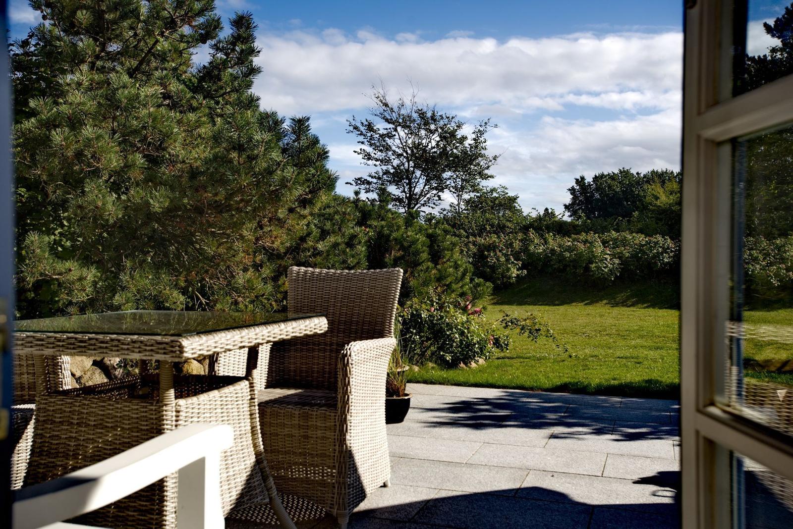Terrace with seating area and view of green garden