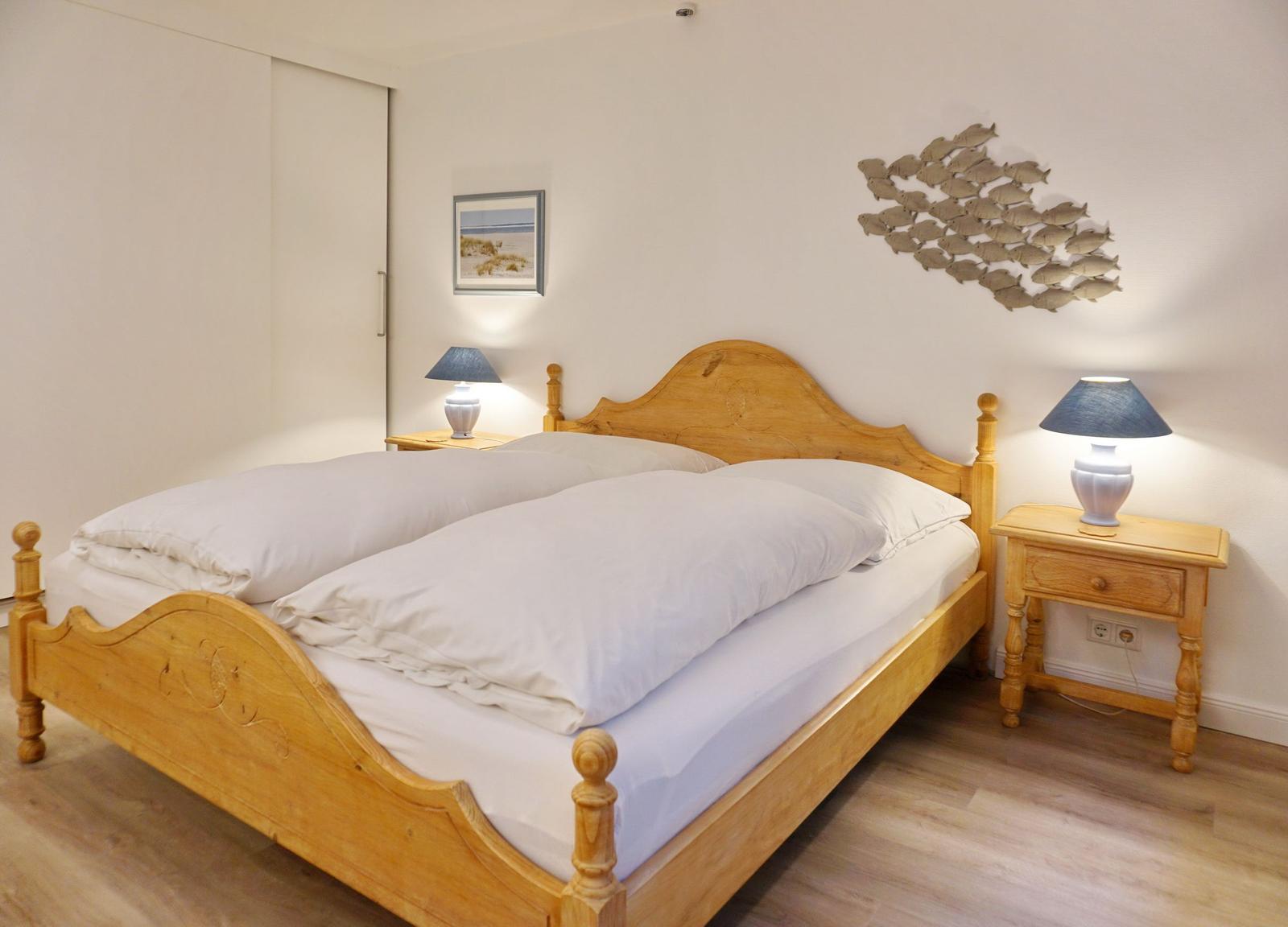 Bedroom with wooden bed, nightstands, and wall decoration.