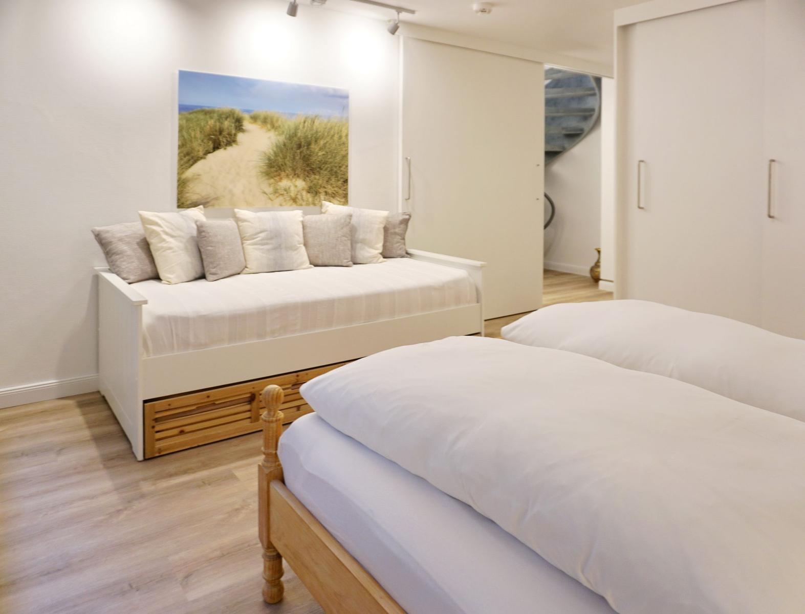 Bedroom with bed, daybed, and wall art
