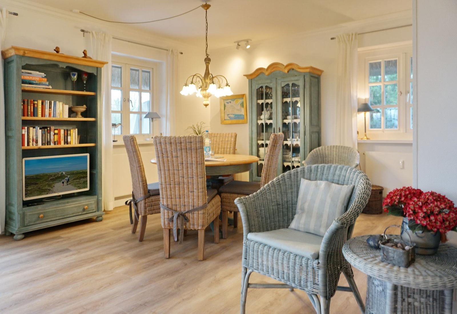 Dining room with table, chairs, and bookcase. TV and decor are visible.