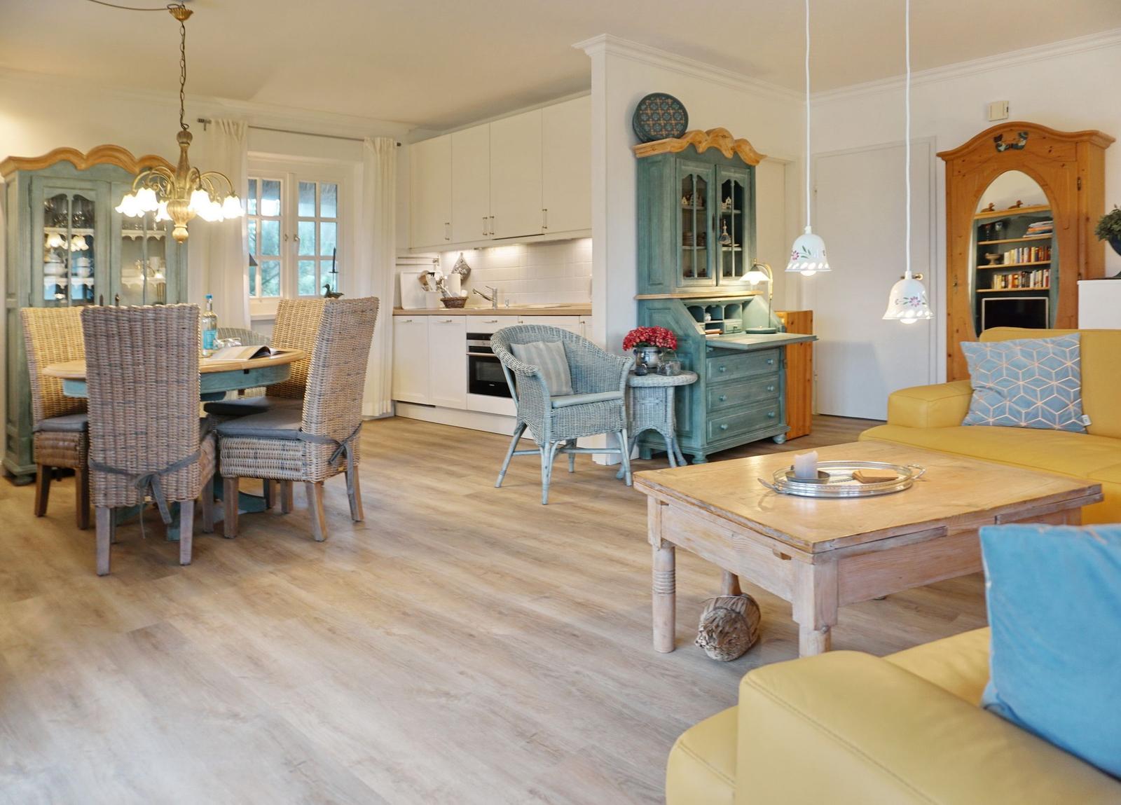 Living and dining area with kitchen, wooden floor, and furniture.