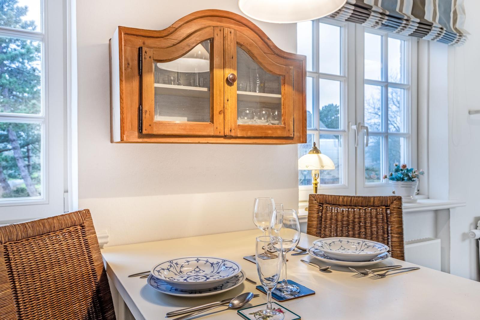 Dining table with chairs, cabinet, and windows