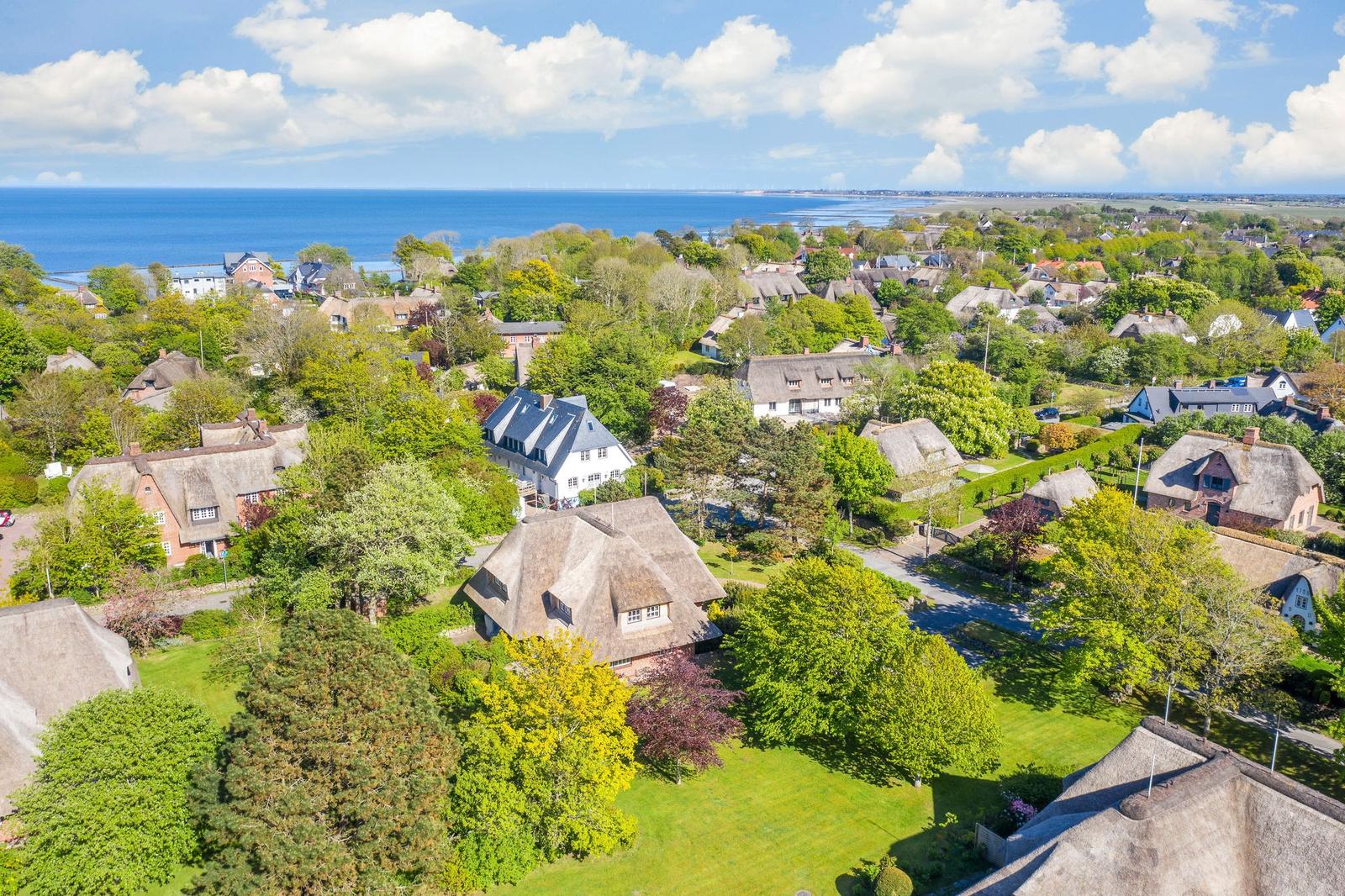 Village with thatched houses and view of the sea