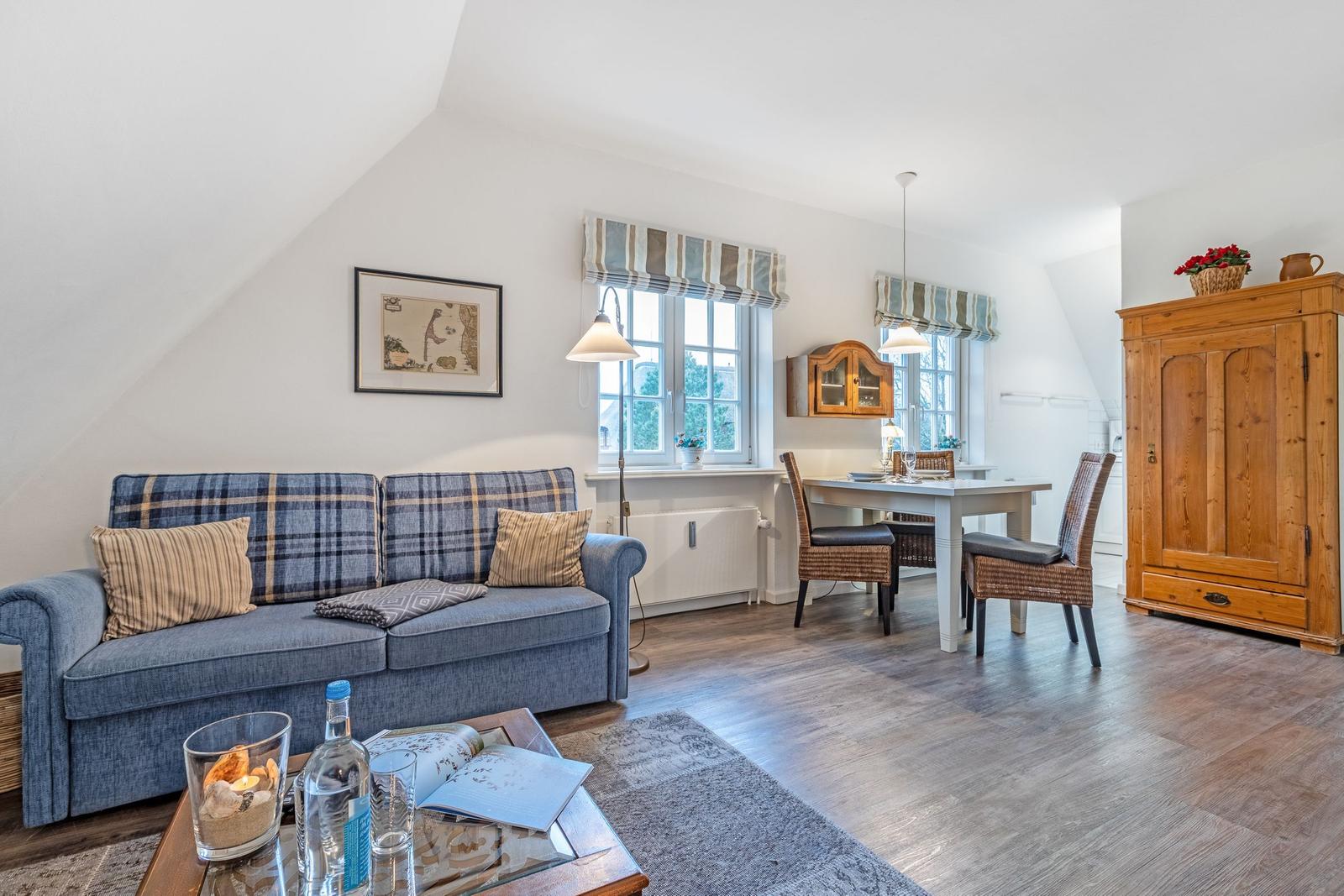 Living and dining area with sofa, table, and wooden cabinet.