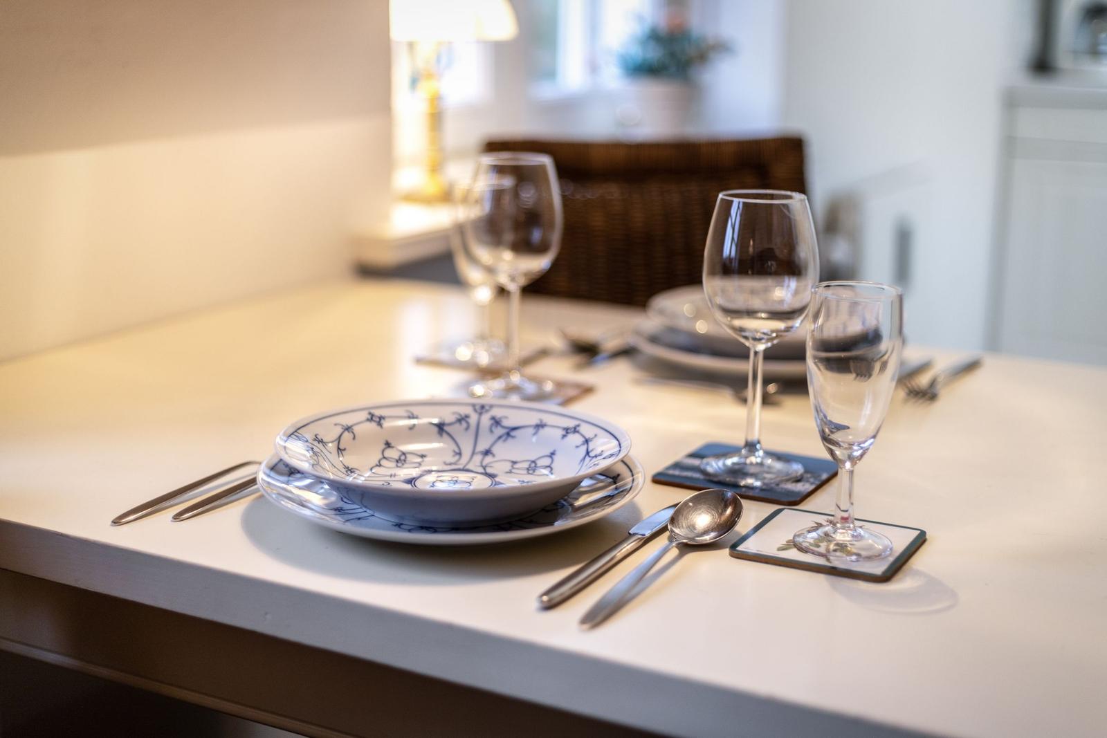 Table set with plates, bowl, glasses, and cutlery.
