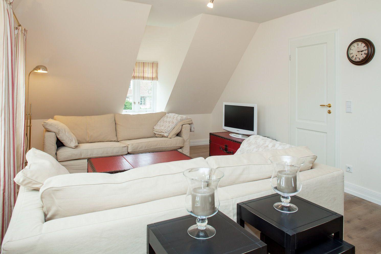 Living room with sofa, coffee table, and TV on the wall.