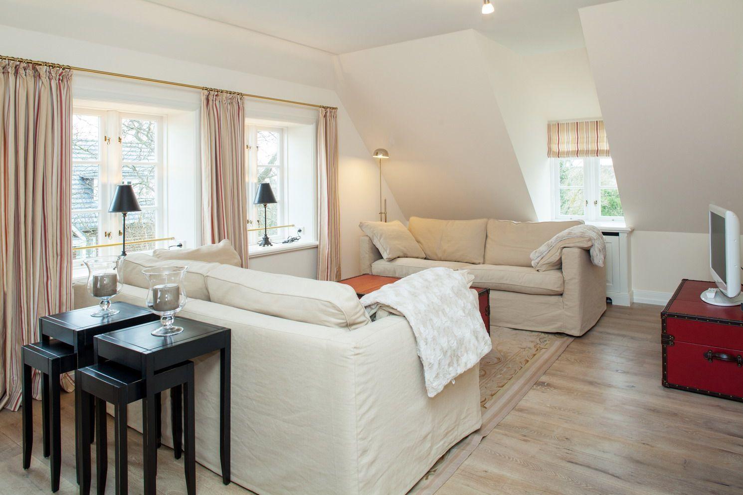 Living room with sofa, windows, and wooden floor.