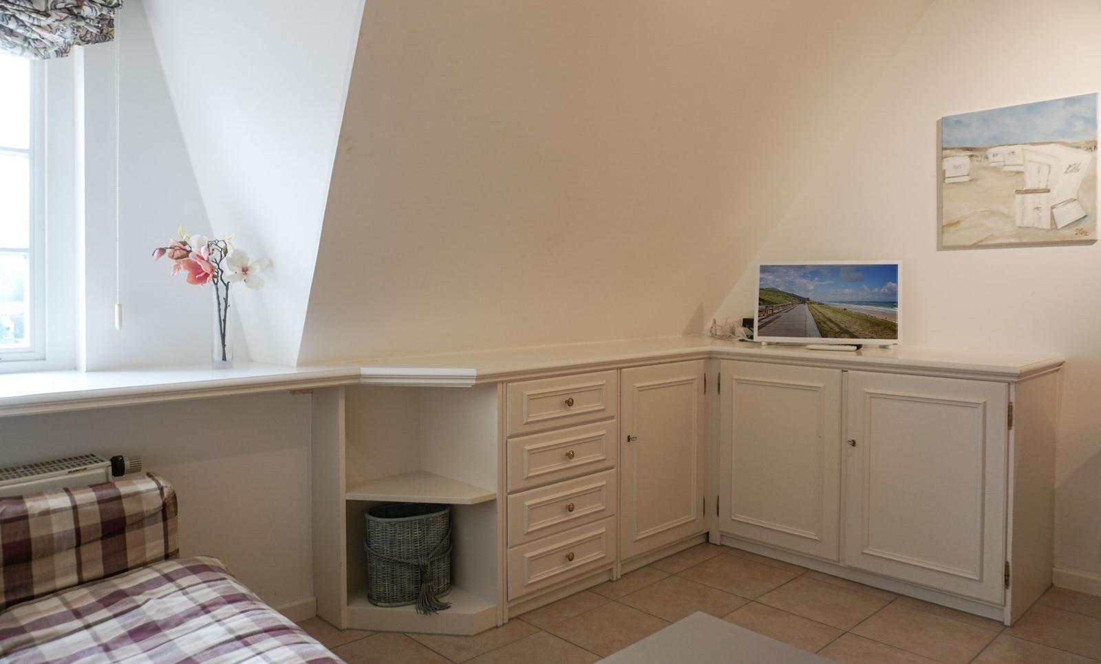Bedroom with sloped ceiling, cabinet, and window