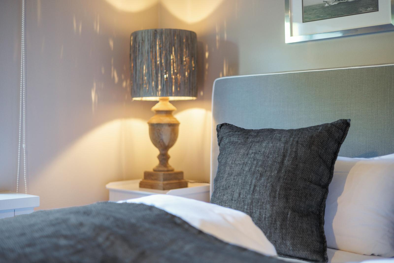 Bedroom with bed, nightstand, and lamp.