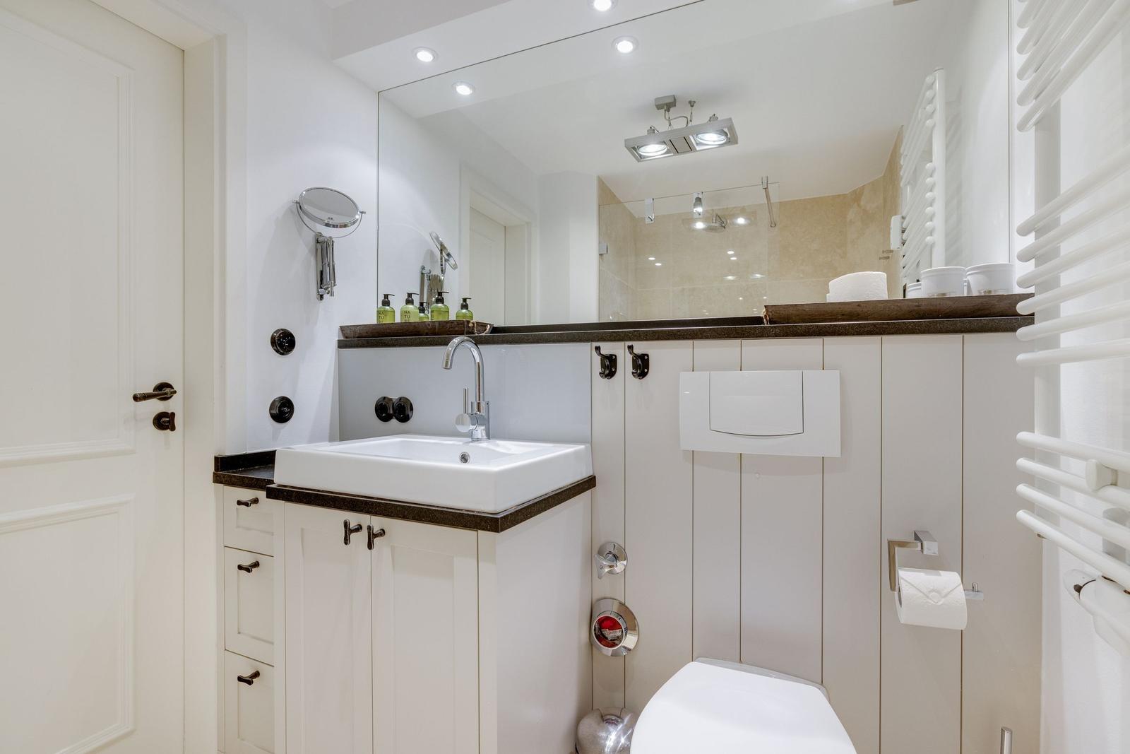 Bathroom with sink, mirror, and toilet.
