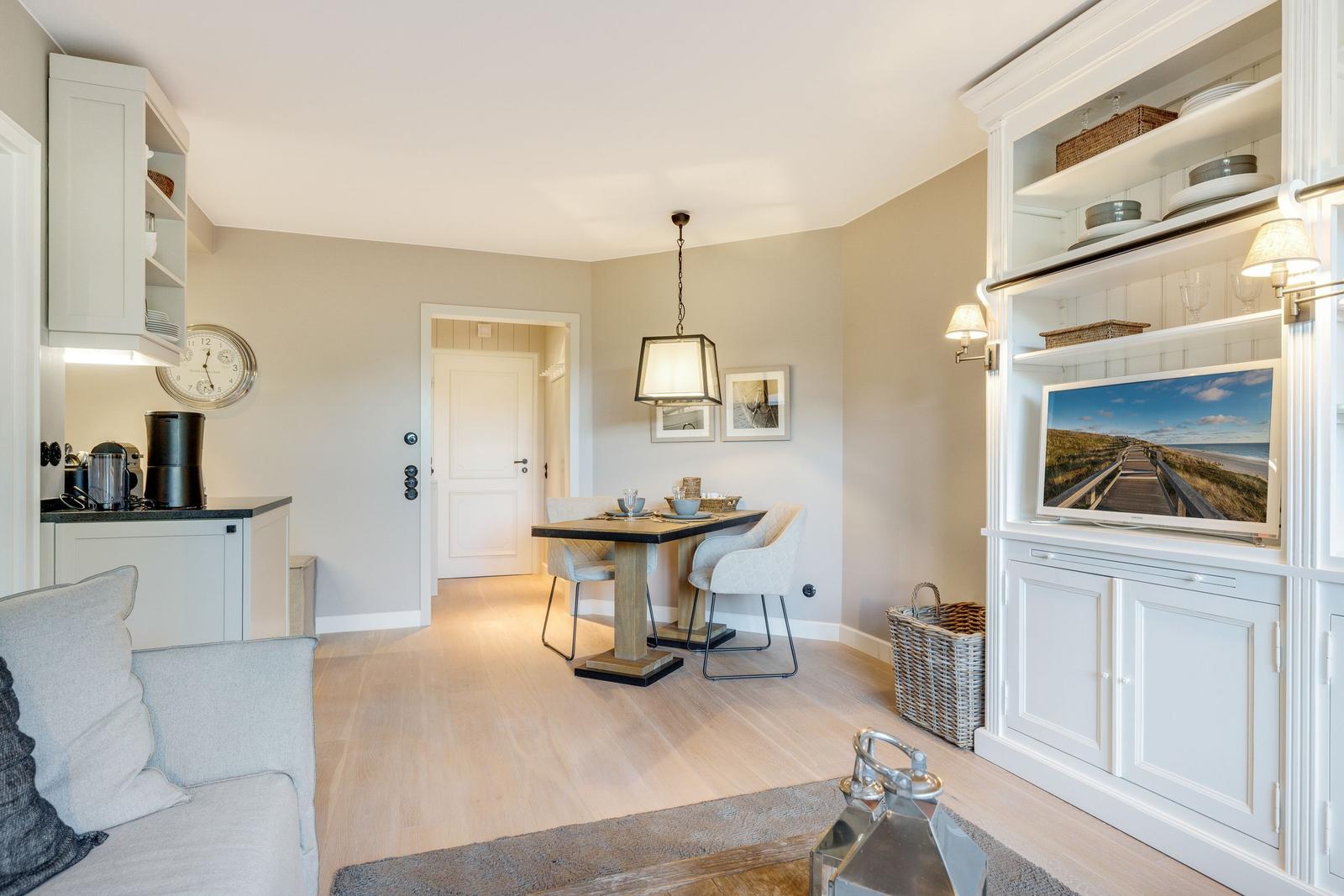Living and dining area with dining table, sofa, and built-in TV cabinet.