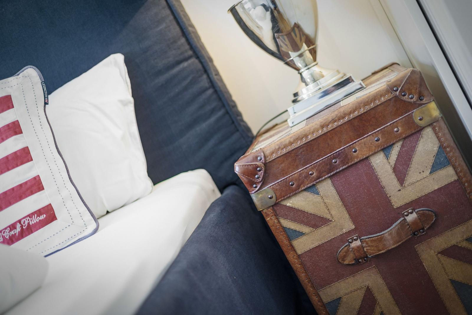 Sofa mit Kissen und Koffer mit Union Jack-Muster.