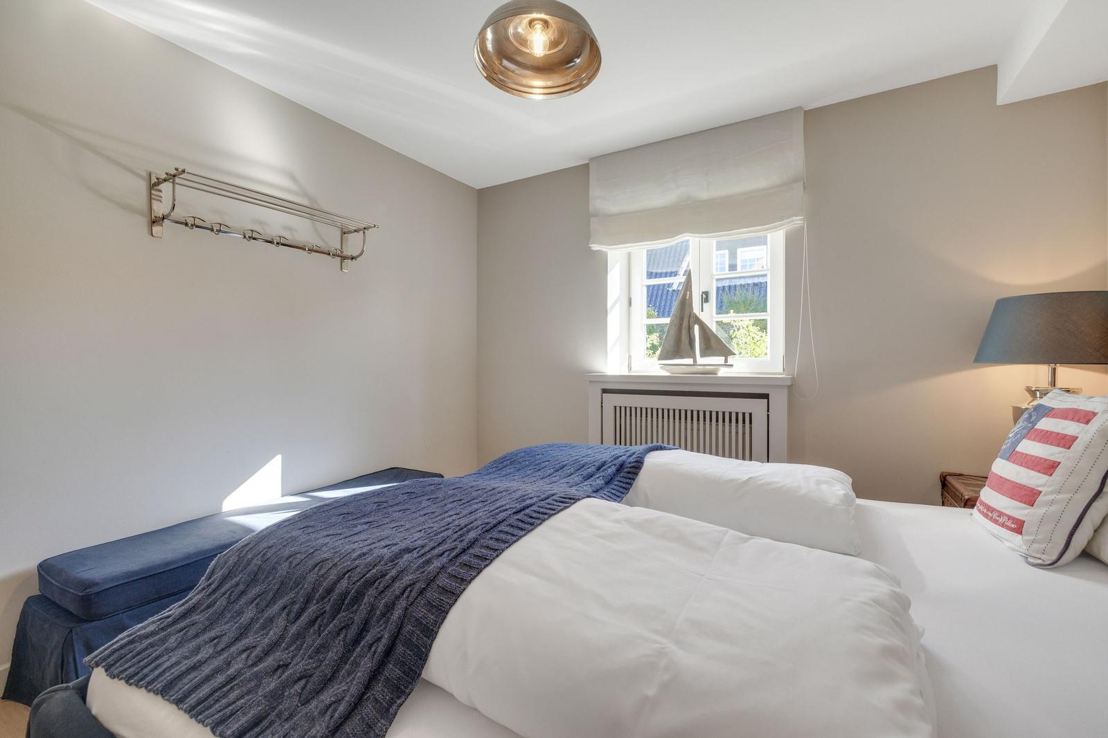 Schlafzimmer mit Bett, Fenster und Decke.