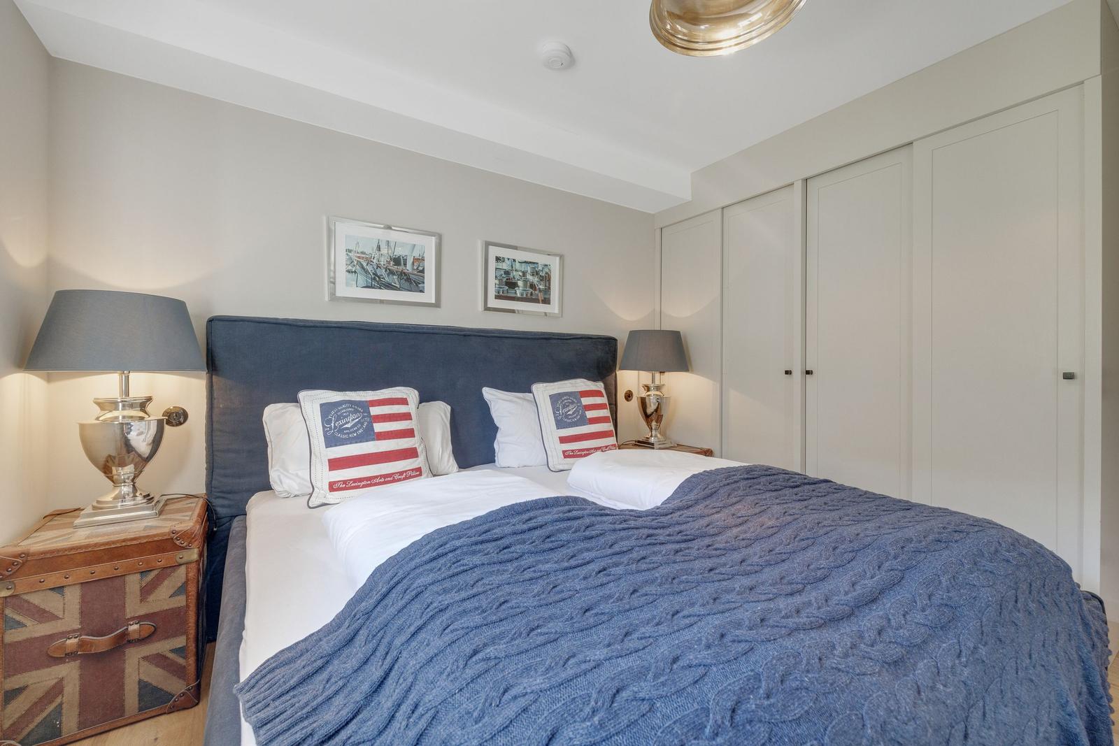 Schlafzimmer mit Bett, Nachttischen und Kleiderschrank.