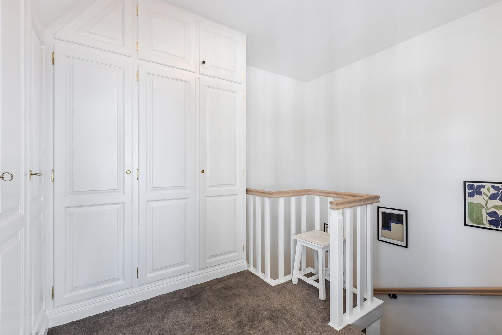 Schlafzimmer mit weißem Schrank und Holzgeländer