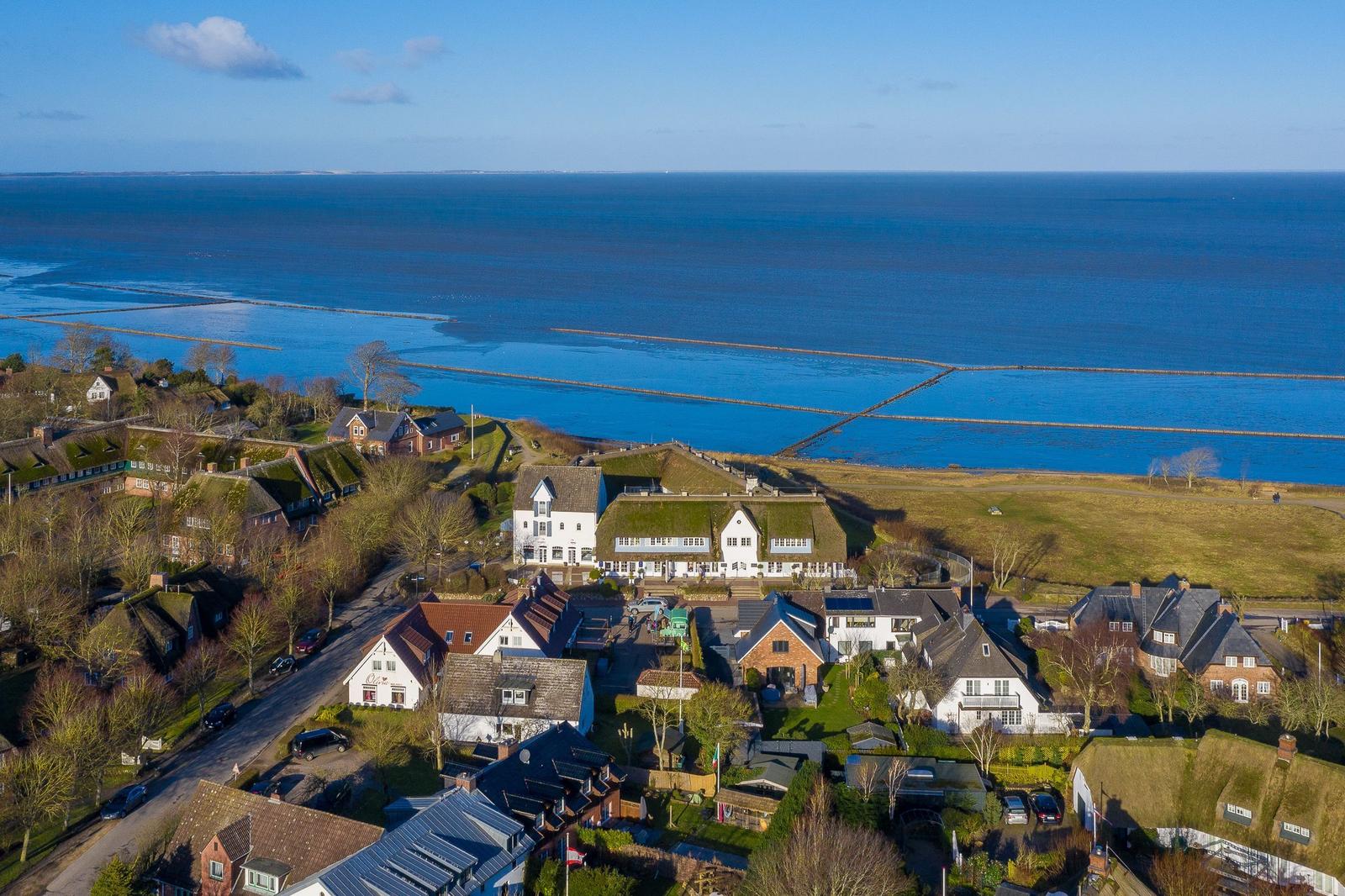 Häuser am Meer mit Grasdächern und Blick auf das Wasser