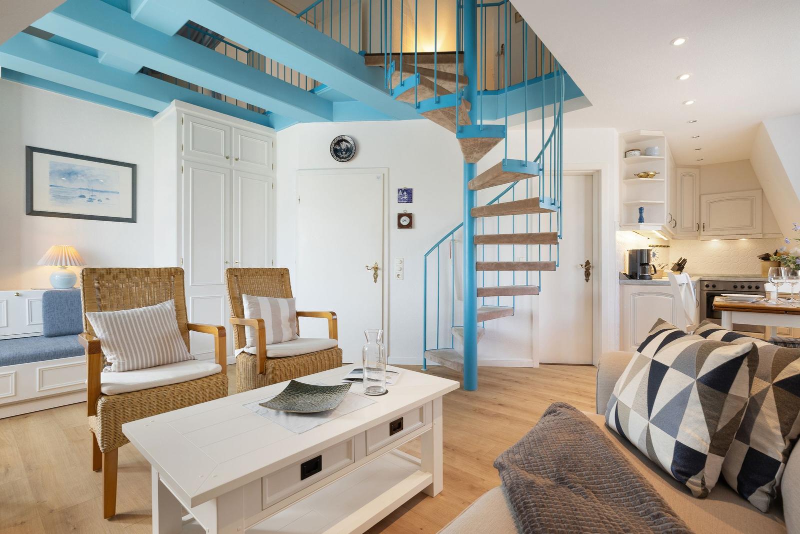 Wohnbereich mit Treppe zur oberen Etage und Küchenbereich im Hintergrund.