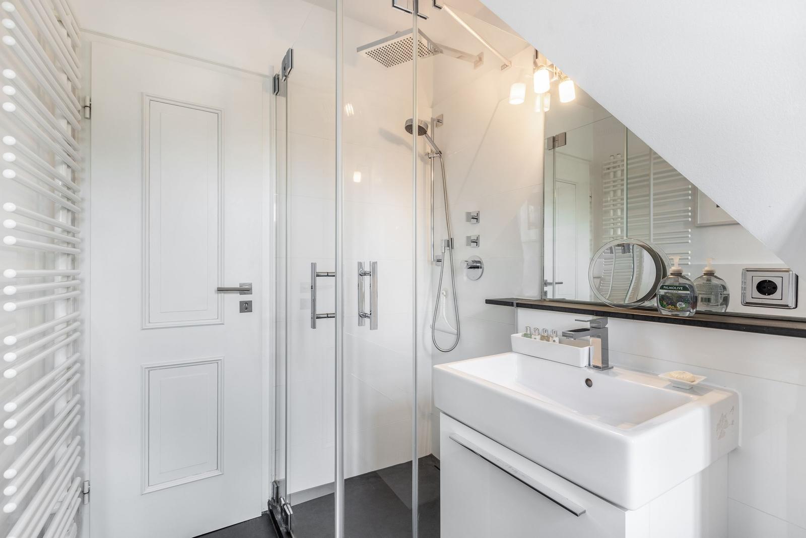 Bathroom with shower, sink, and heater.