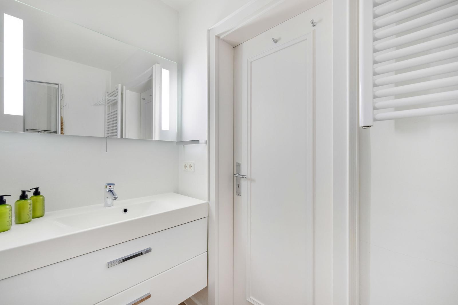 Bathroom with sink, mirror, and heater