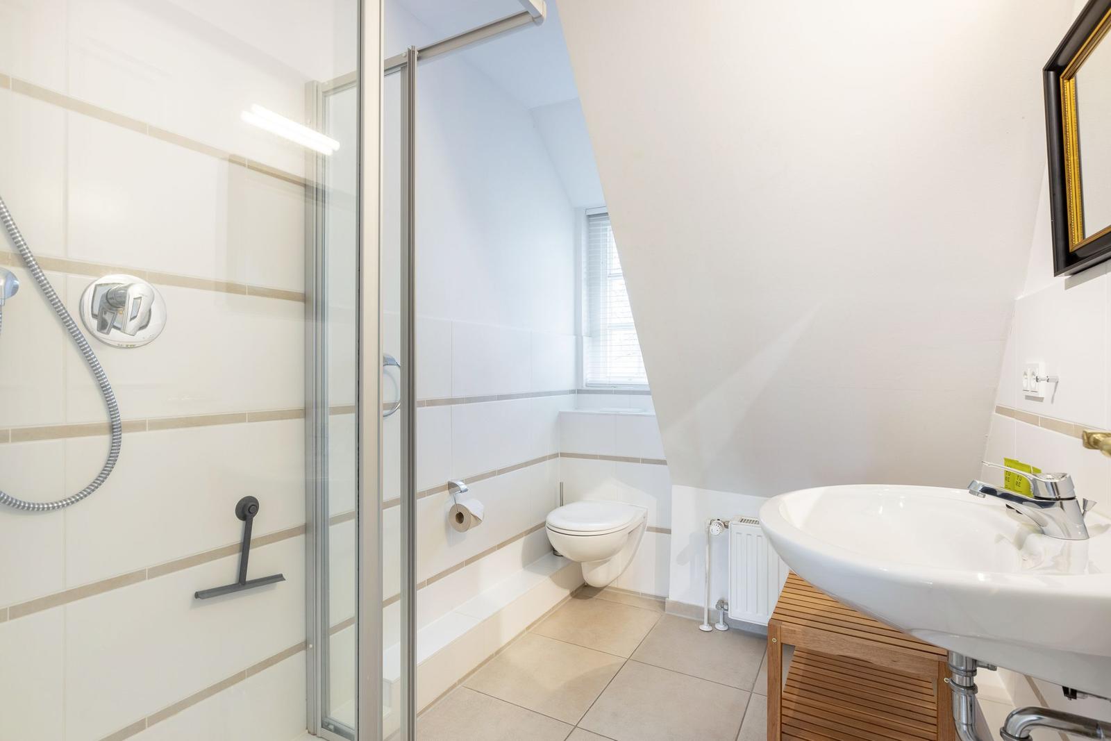 Badezimmer mit Dusche, Toilette und Waschbecken