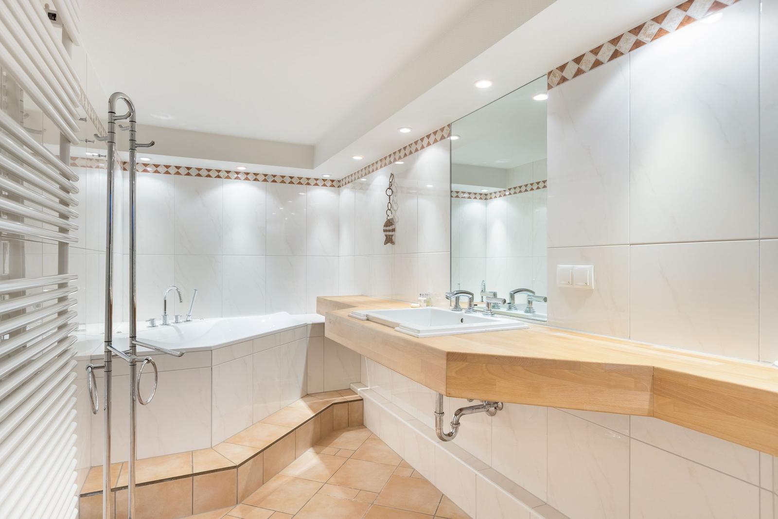 Badezimmer mit Badewanne, Waschtisch und Spiegel