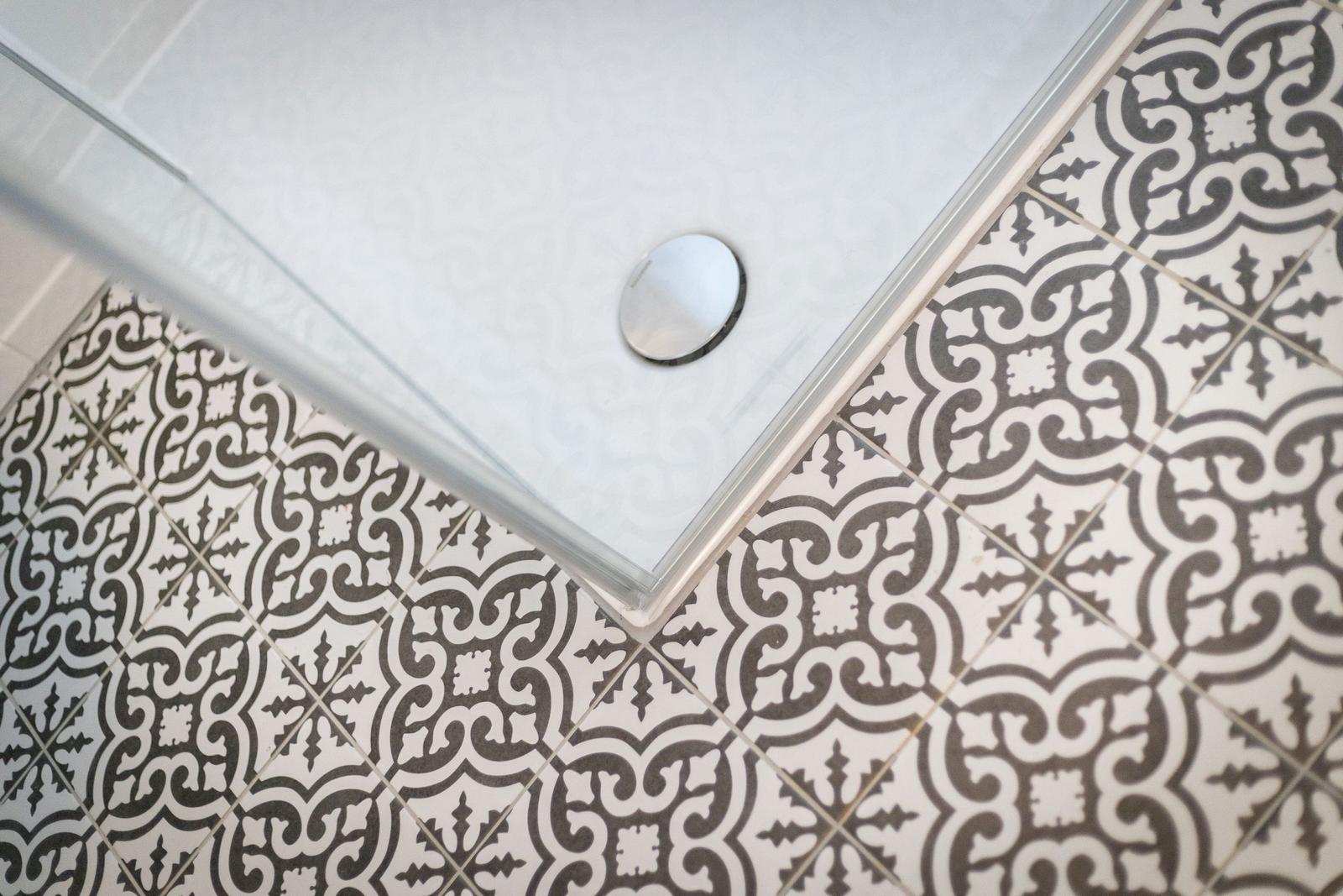 Shower tray with mosaic tiles in bathroom