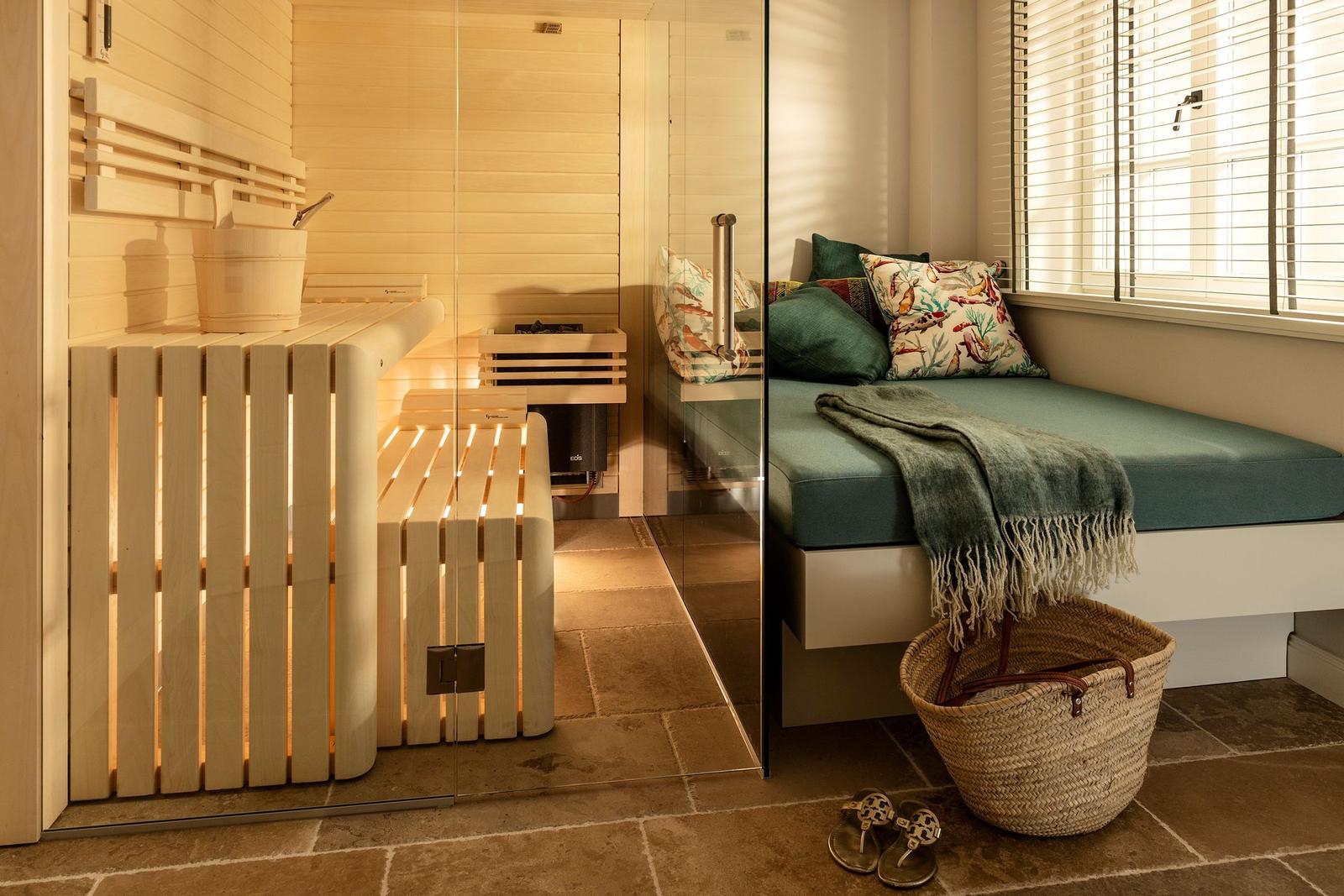 Sauna mit Holzbank und Fensterbank mit Kissen und Decke.