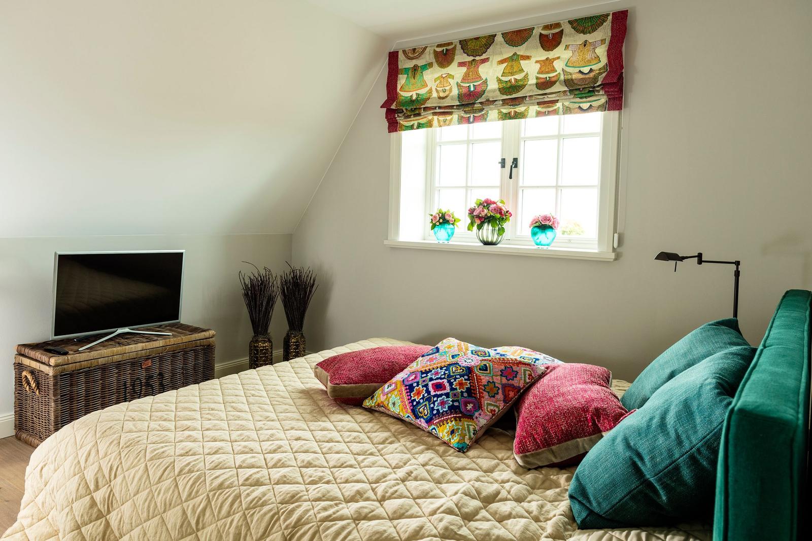 Schlafzimmer mit Bett, Fenster und Fernseher