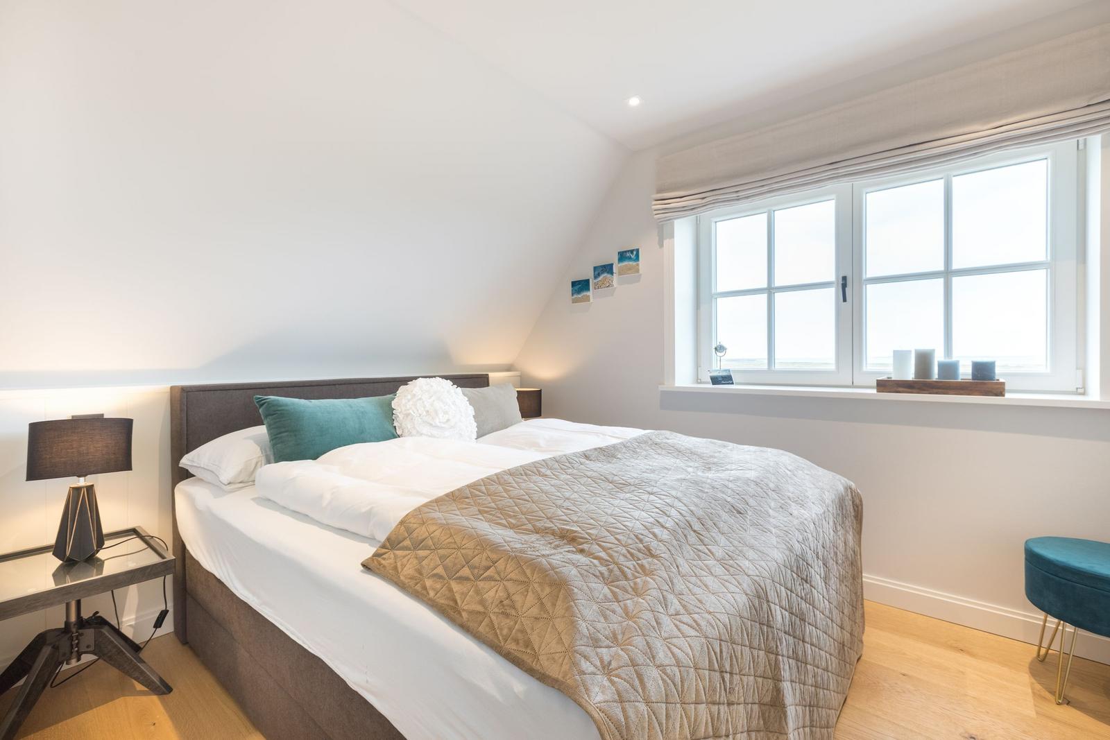 Schlafzimmer mit Doppelbett, Fenster und Nachttisch