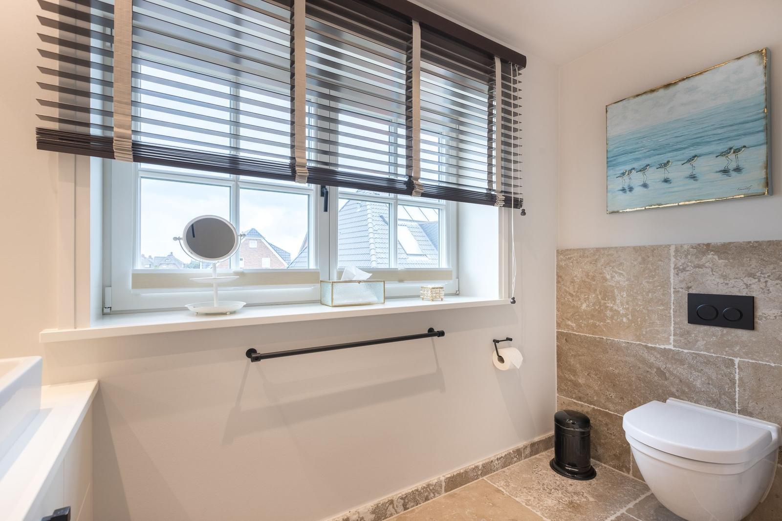 Badezimmer mit Fenster, Toilette und Wandbild