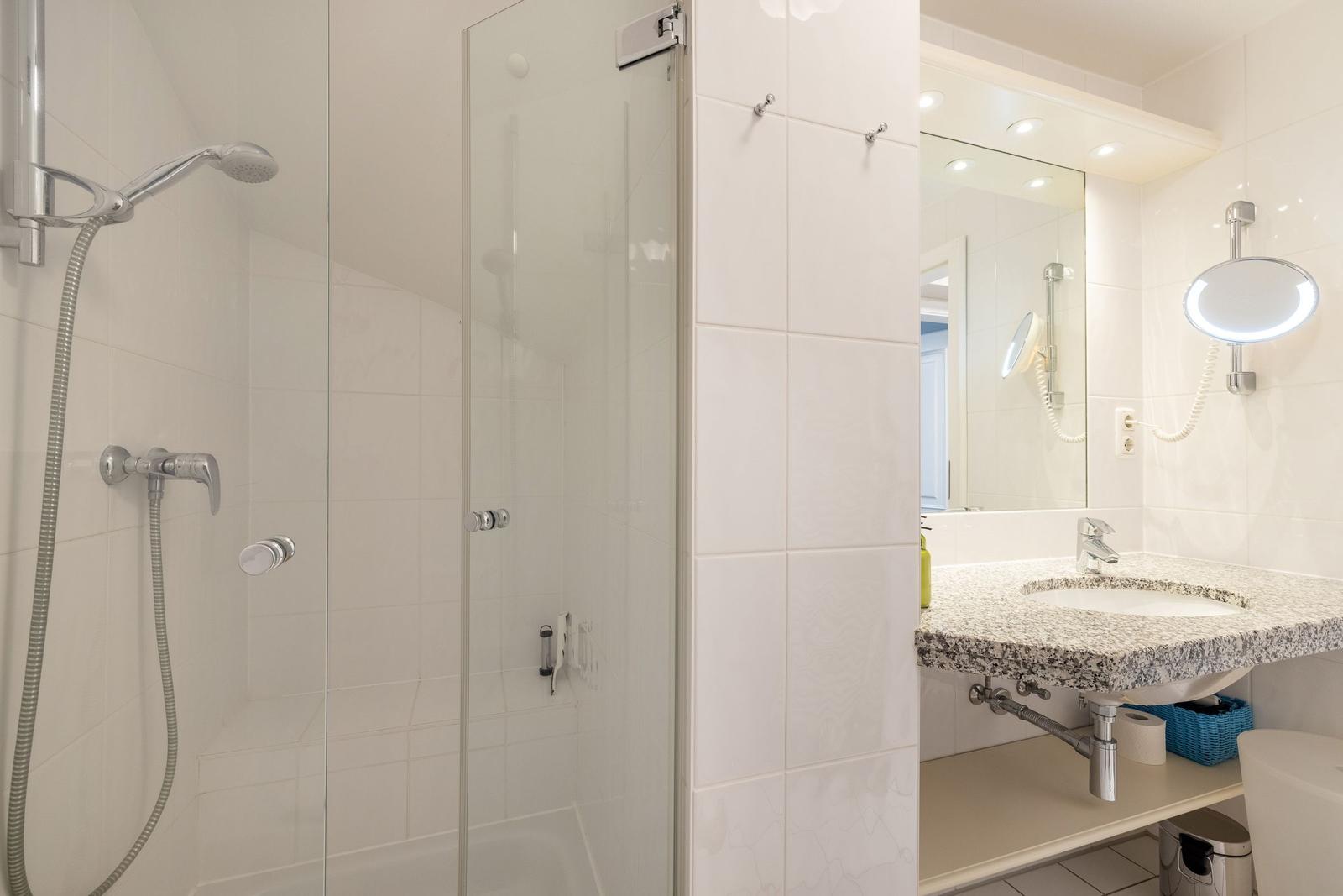 Bathroom with shower, sink, and mirror.