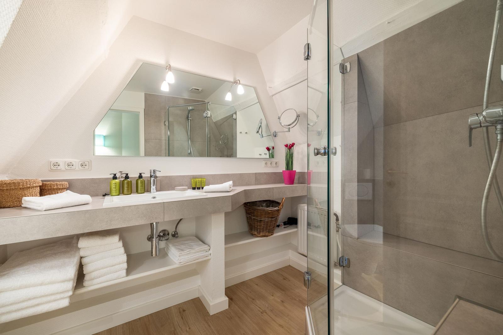 Bathroom with shower, sink, and towels