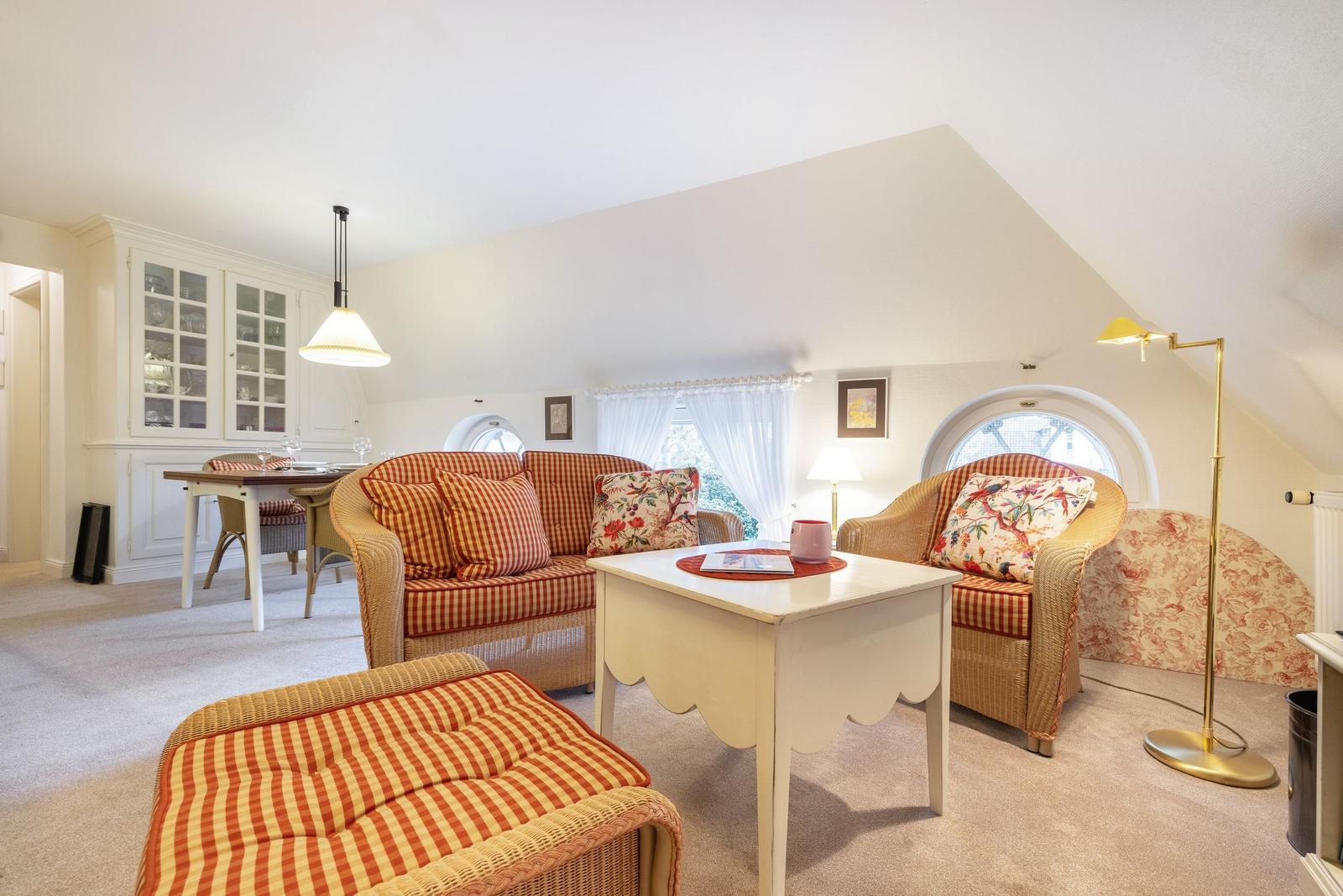 Living and dining area with seating, table, and windows.