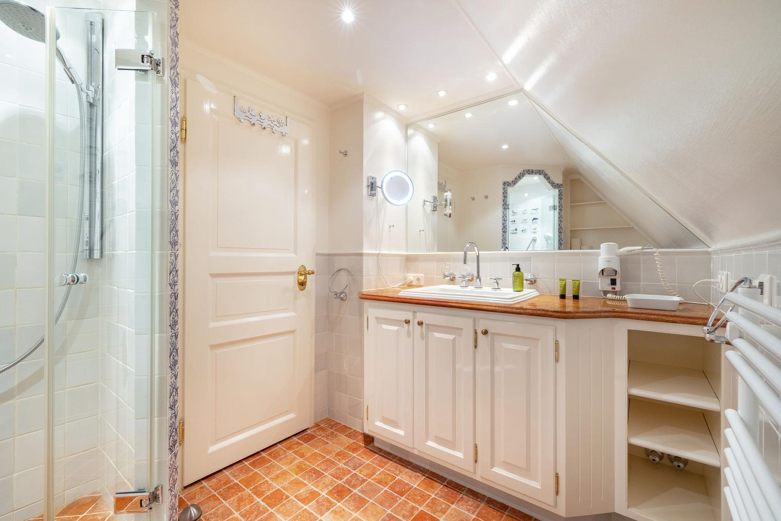Bathroom with shower, sink, and mirrors.