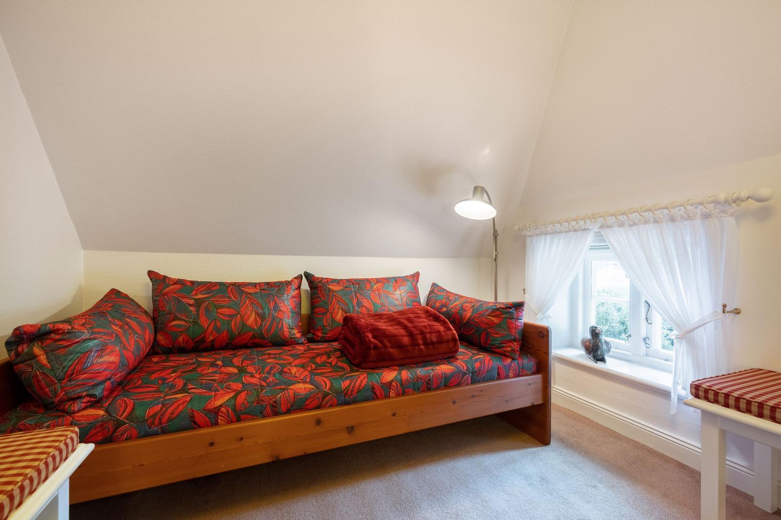 Bedroom with daybed, window and standing lamp