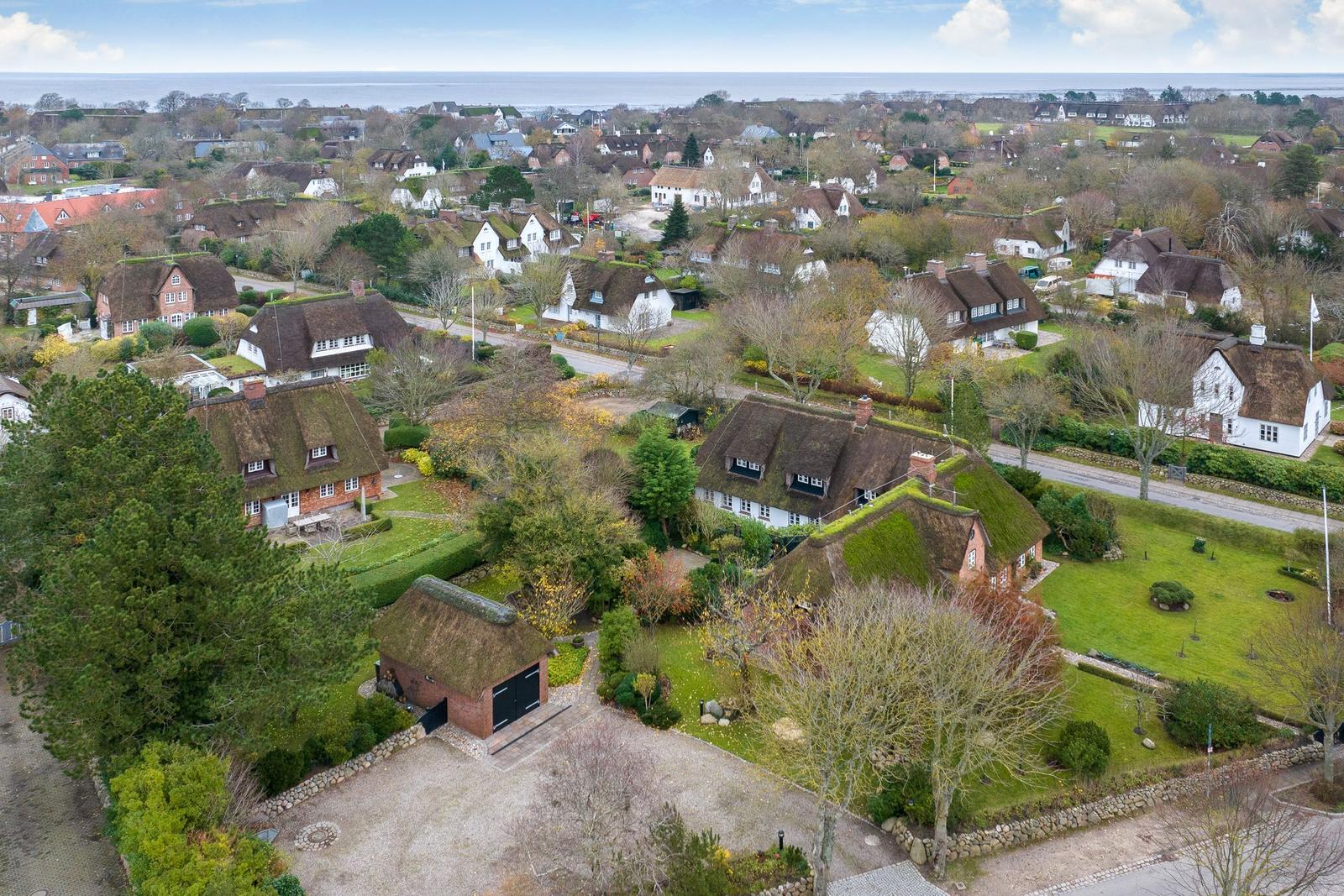 Village with thatched houses and view of the sea.