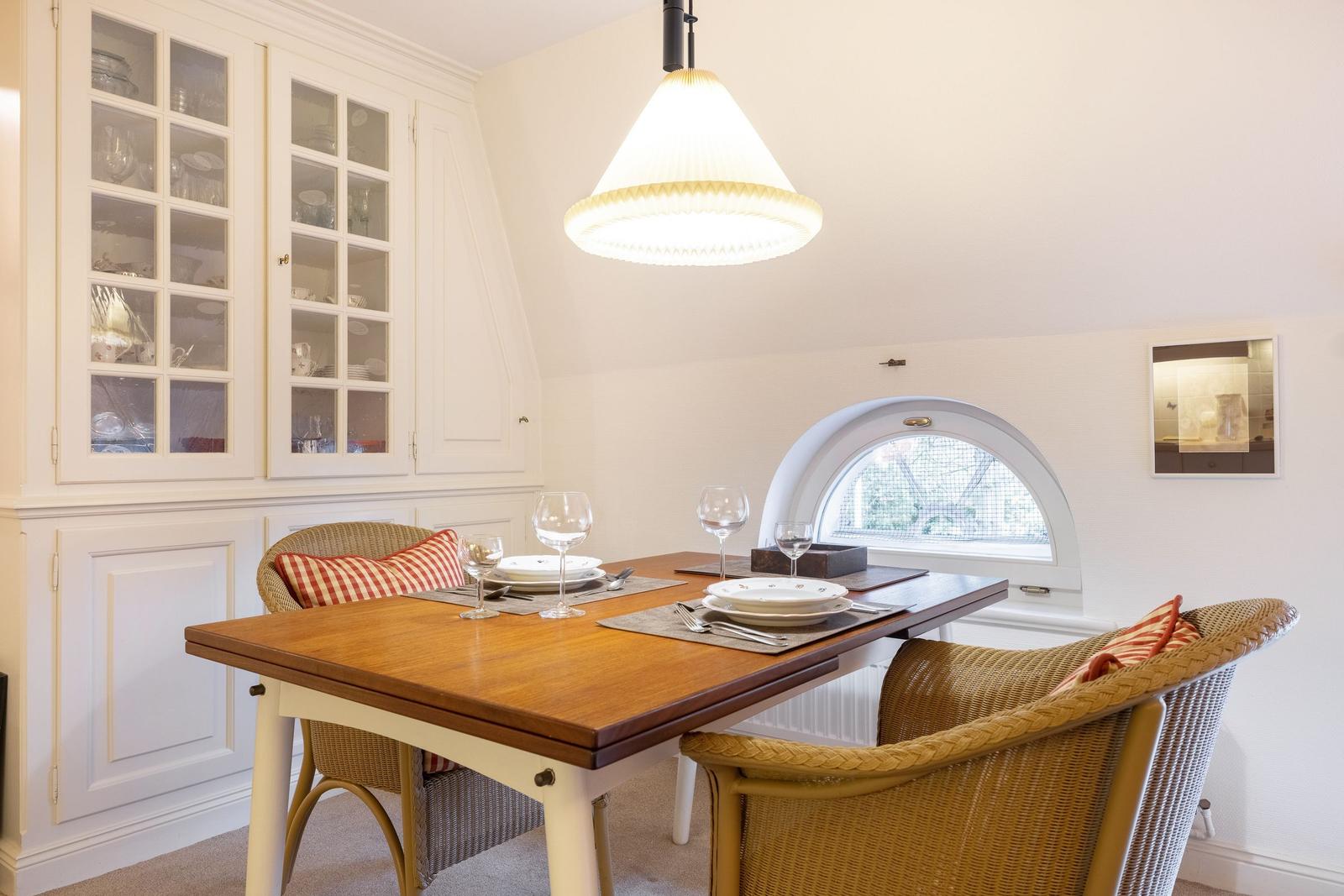 Dining table with chairs and glass cabinets on the wall.
