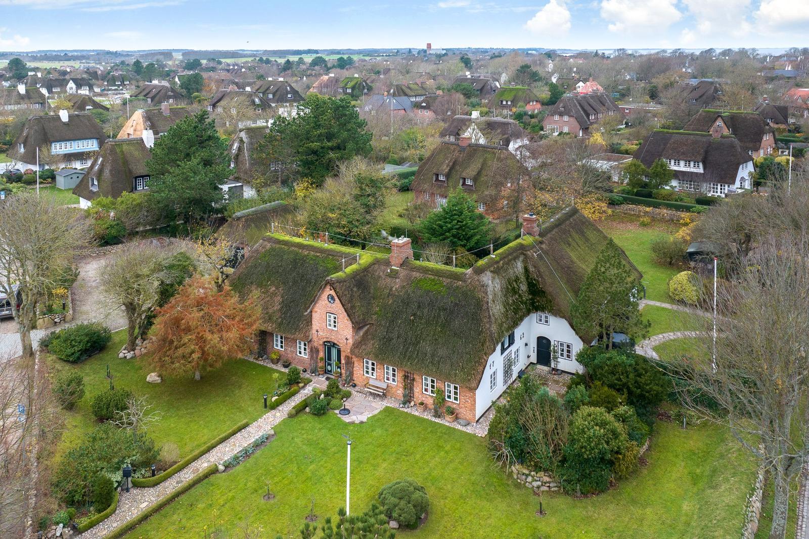 House with thatched roof, garden, and view of villages