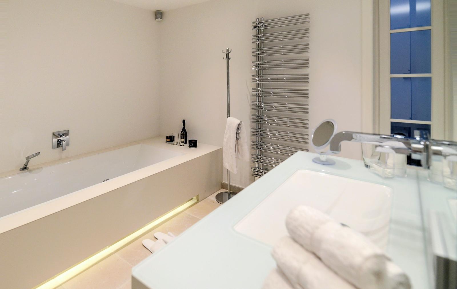Badezimmer mit Badewanne, Waschbecken und Heizkörper