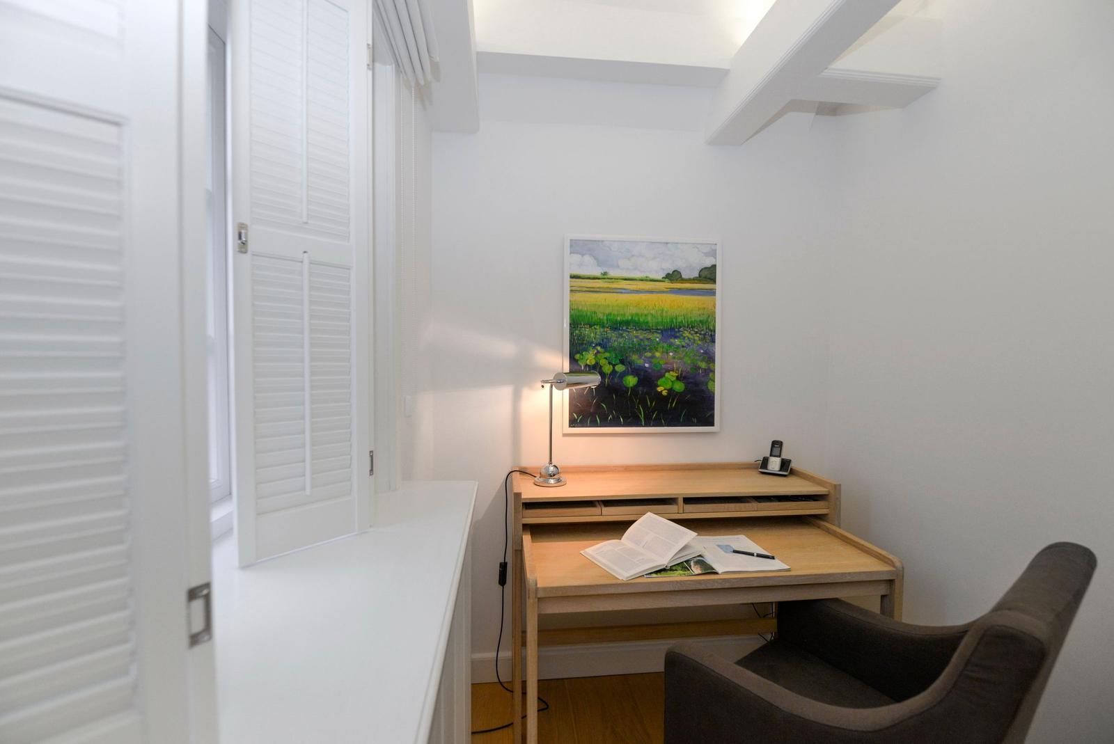 Schreibtisch mit Stuhl und Bild an der Wand