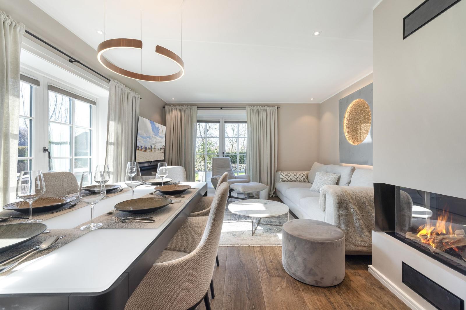 Modern eingerichtetes Wohn- und Esszimmer mit Kamin und Essplatz.