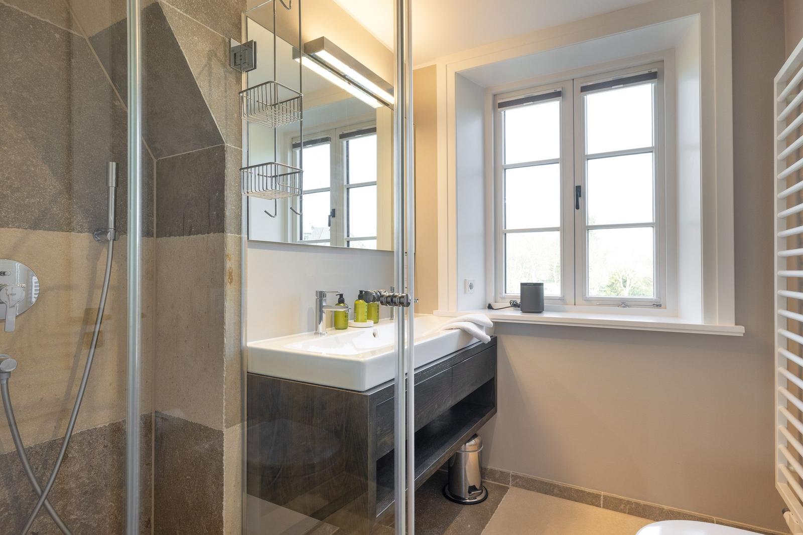 Bad mit Dusche, Waschbecken und Fenster
