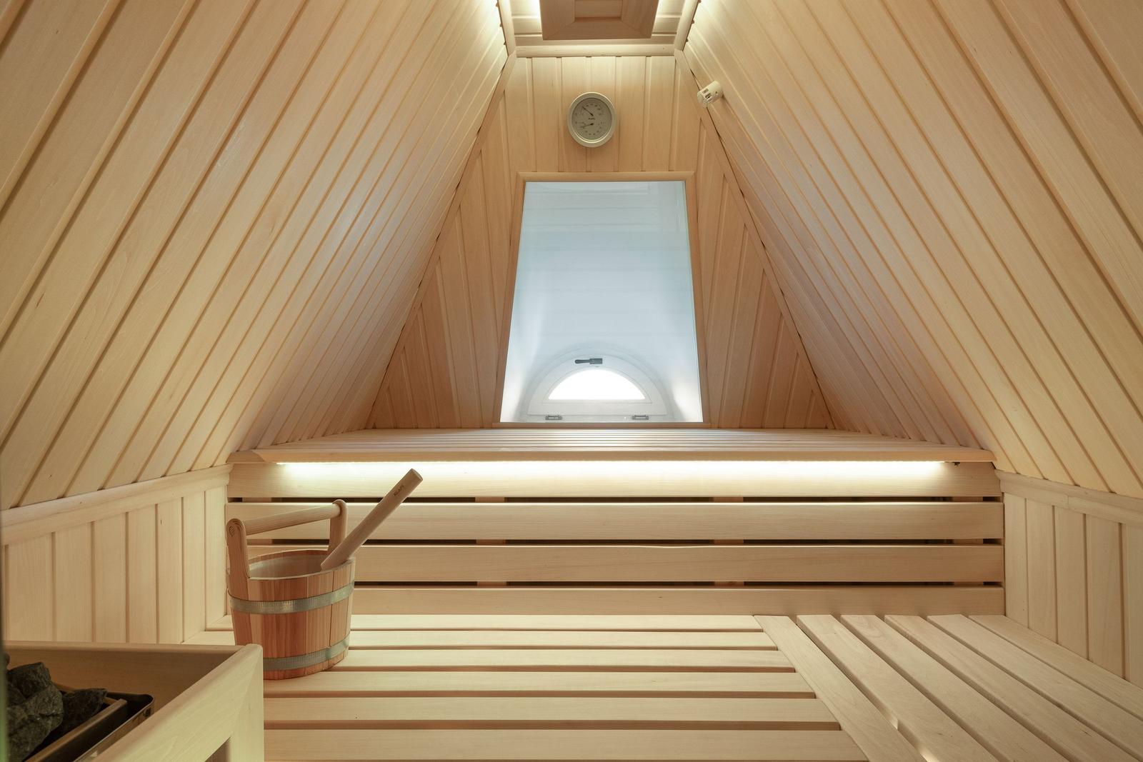 Sauna mit Holzbank, Eimer und Fenster