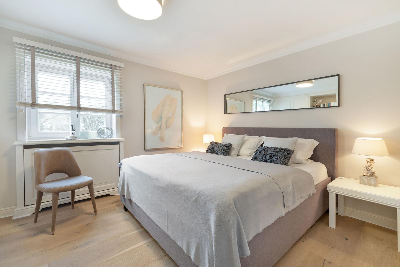 Bedroom with bed, nightstand, chair, and window