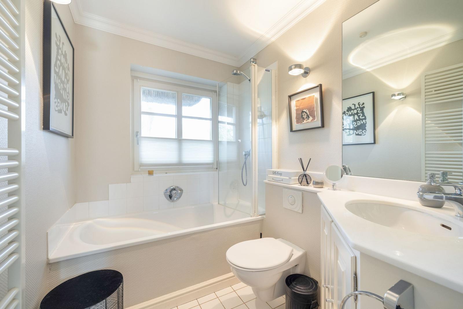 Bathroom with bathtub, shower, sink, and toilet.